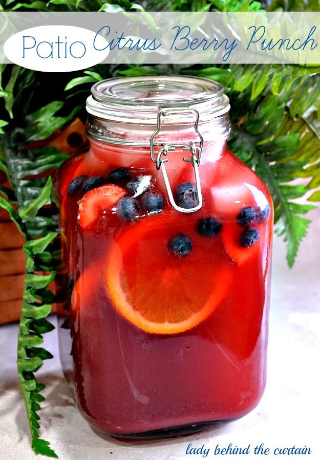 a mason jar filled with red liquid and sliced oranges