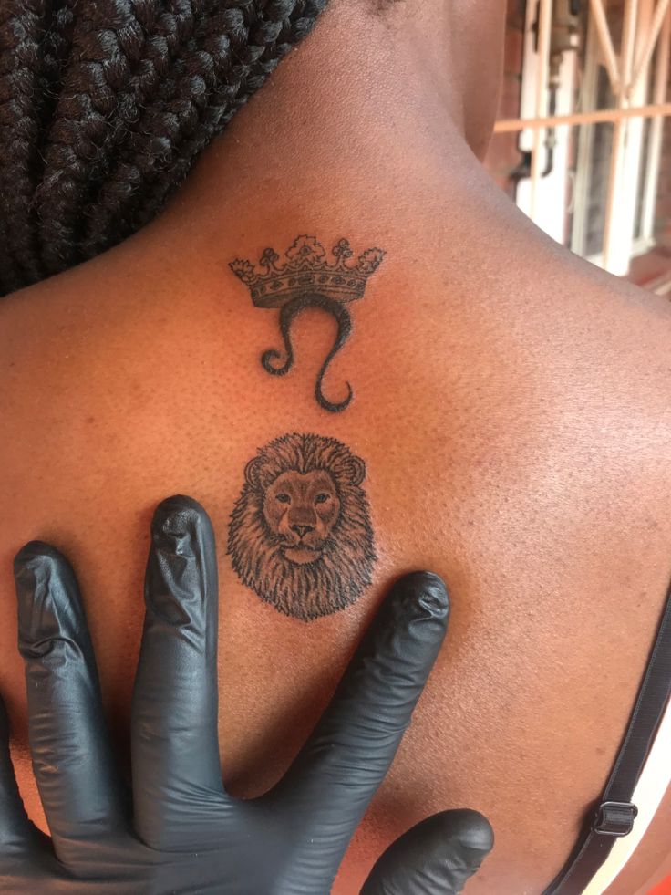 a woman's back with an elephant and lion tattoo on it