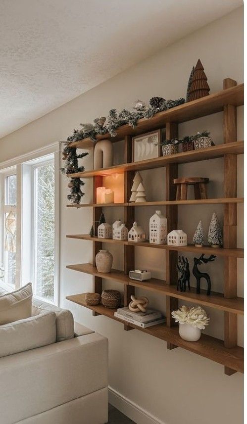 a living room filled with white furniture and lots of bookshelves on top of wooden shelves