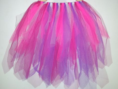 a pink and purple tulle skirt hanging on a wall