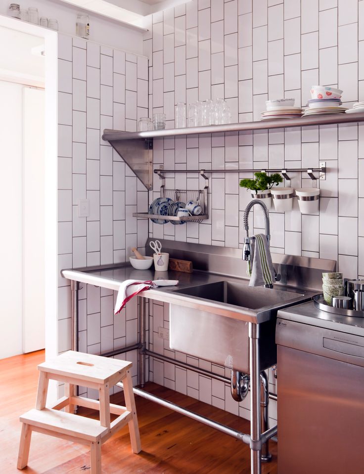 a kitchen with stainless steel appliances and wooden floors