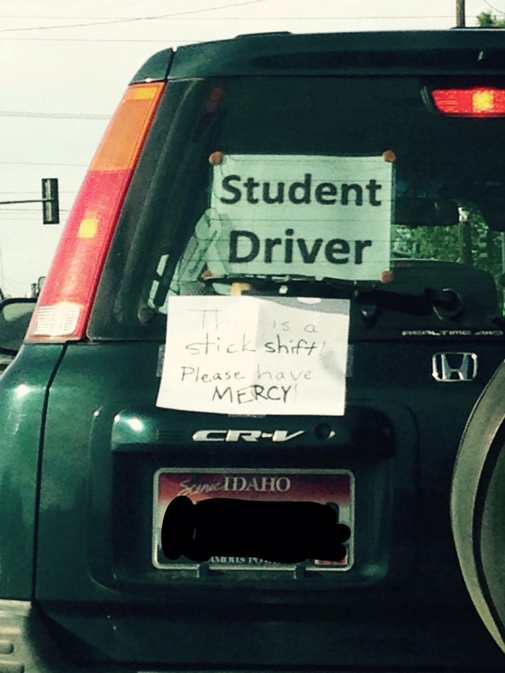 there is a sign on the back of a car that says student driver and it's attached to a bike rack