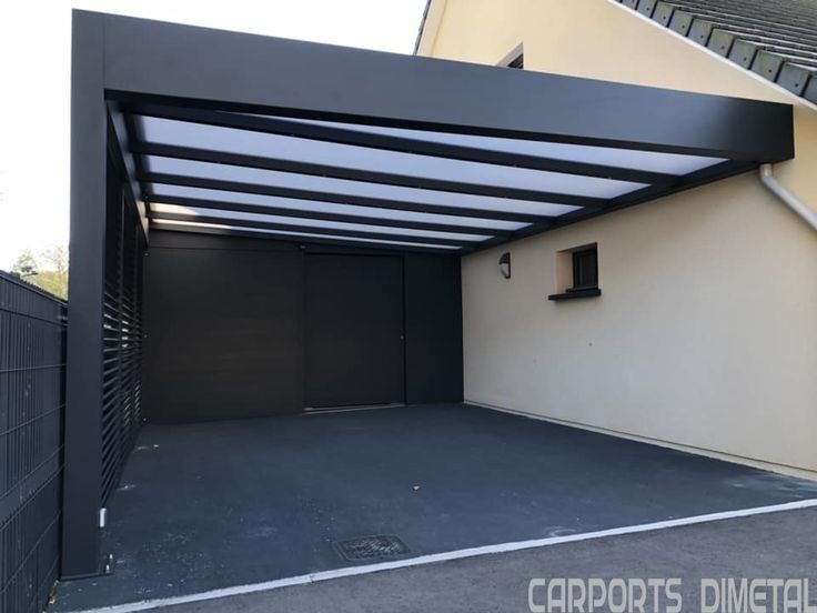 an open garage door on the side of a house with a black fence around it