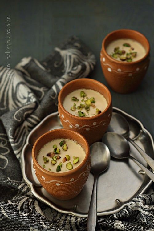 three bowls of soup on a plate with spoons