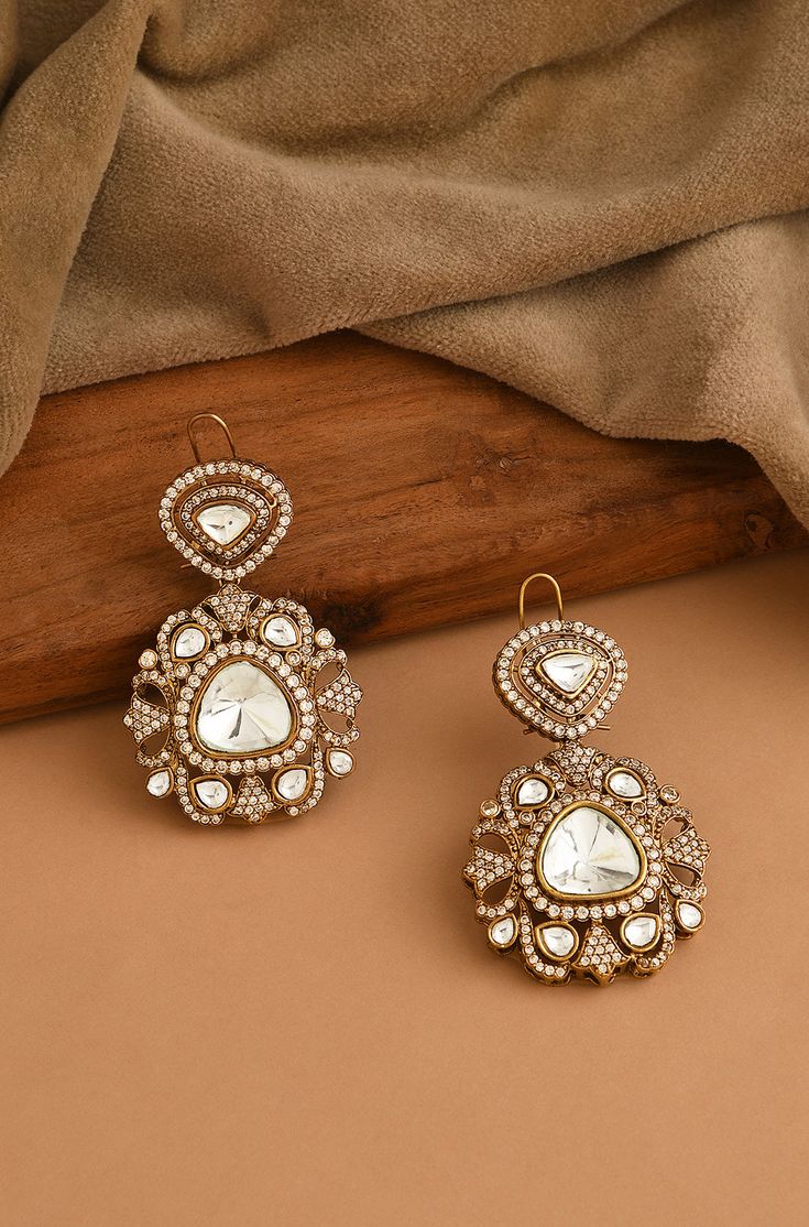 Elevate your style with our Victorian Polki Earrings, showcasing an eye-catching design with uncut polkis and gleaming cubic zirconia. This elegant pair effortlessly lights up any room, transitioning seamlessly from morning to night and providing the perfect extra sparkle to your ensemble. Finish: 22KT Gold Plating Material: Silver, Copper Alloy, Polki Color: Gold Size: One Size Closure Type: Push Back Box Contains: 1 Pair of Earrings Victorian Polki Earrings, Gold Earrings Indian Jhumkas, Indian Victorian Jewellery, Polki Earrings Designer, Victorian Earrings Indian, Victorian Gold Jewelry, Polki Earrings Studs, Indian Jewelry Photography, Indian Jewellery Photography