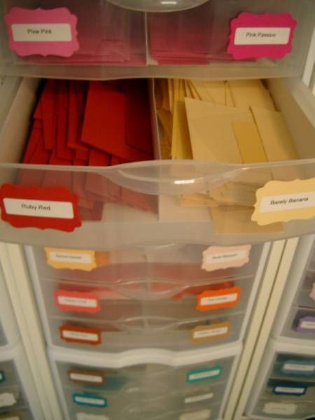 an organized file cabinet filled with files and folders, labeled in pink labels on the drawers