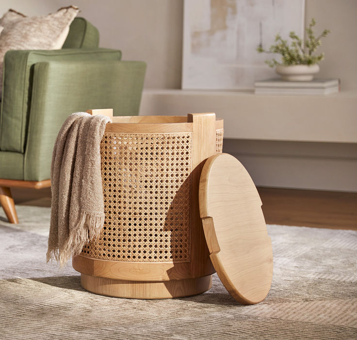 a wooden trash can sitting on top of a rug next to a green couch and chair