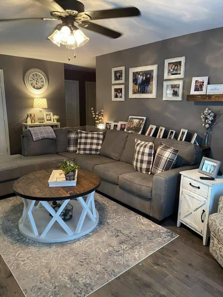 a living room filled with furniture and pictures hanging on the wall behind a coffee table