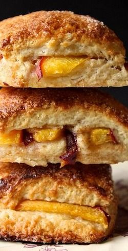 two biscuits stacked on top of each other with peaches and cheese in the middle