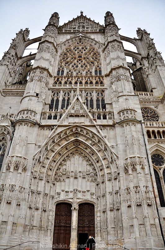 two people are standing in front of a large building with gothic architecture on it's sides