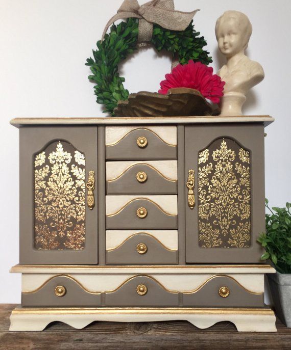 an old dresser has been painted gold and white