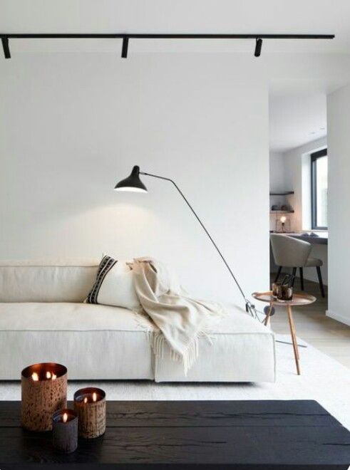 a living room with a white couch and two candles