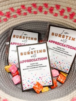 two booklets sitting on top of a basket filled with candy