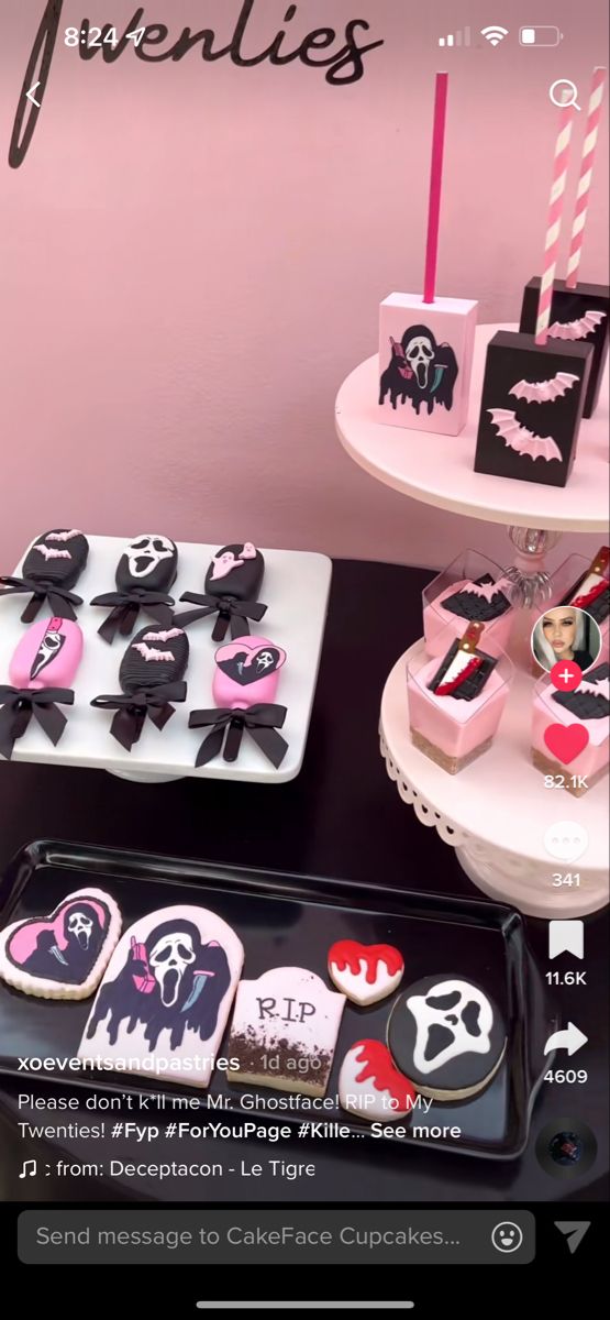 a table topped with lots of cakes and cupcakes covered in icing next to a pink wall