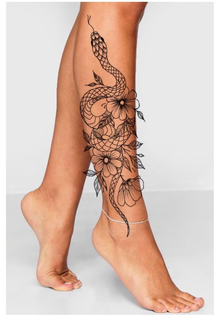 a woman's legs with tattoos and flowers on the side of her leg is shown