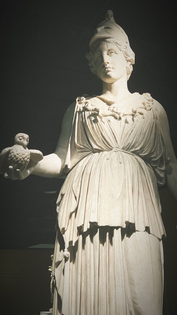 an image of a statue that looks like she is holding something in one hand and a bird in the other