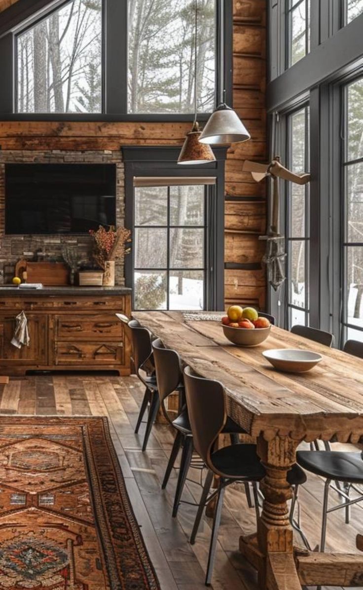 a large wooden table sitting in the middle of a living room with lots of windows