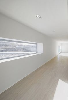 an empty room with white walls and wood flooring is seen in this image from the inside