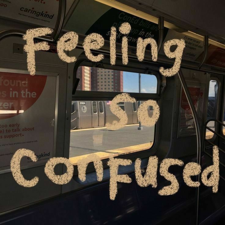 the words feeling so confused are written in front of a window on a subway train