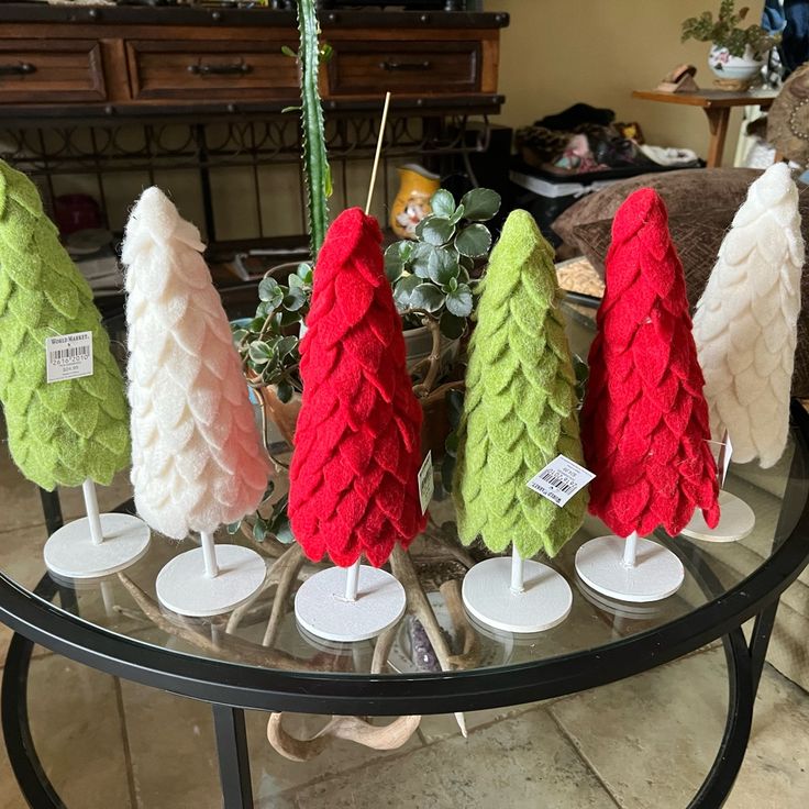 small christmas trees sitting on top of a glass table