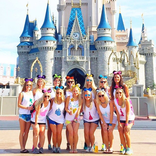 a group of girls standing in front of a castle