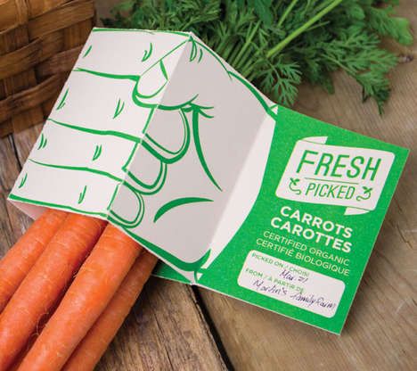 carrots are sitting on a wooden table next to a box of fresh and picked carrots