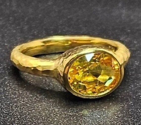 14k solid yellow gold hammered ring with 3.75 ct. 10x8 mm oval shape natural yellow sapphire, this item can also be ordered in white or rose gold with different color gemstones such as, amethyst, pink amethyst, green amethyst, blue topaz, London blue topaz, white topaz, citrine, garnet, smoky quartz, peridot, aquamarine, morganite & pink tourmaline, please contact me for a quote as each gemstone varies in price. I am a manufacturer of fine jewelry for over thirty years, loyalty and customer sati Gold Oval Yellow Sapphire Ring, Oval Yellow Sapphire Ring In Gold, Oval Yellow Sapphire Ring In Yellow Gold, Oval Yellow Sapphire Jewelry With Polished Finish, Gold Oval Faceted Ring, Oval Gold Faceted Rings, Gold Faceted Sapphire Ring, Gold Sapphire Ring With Gemstone, 14k Gold Yellow Sapphire Ring