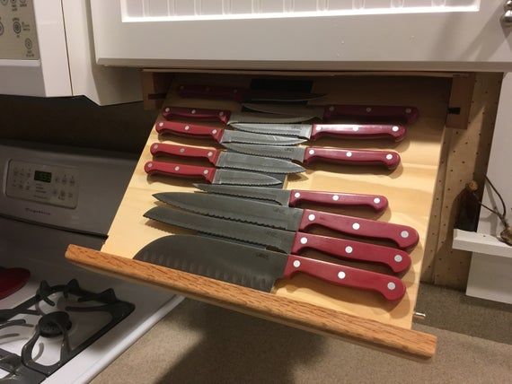 several knives are sitting in a drawer on the counter