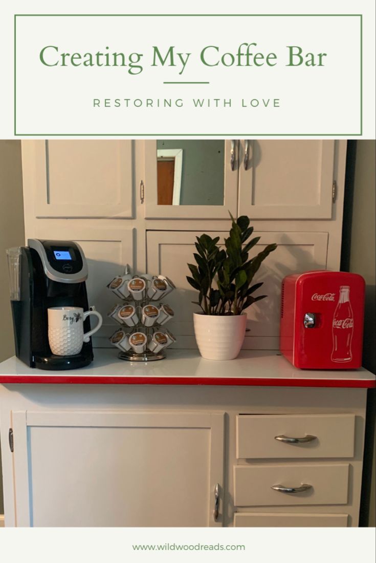 a coffee bar with white cabinets and red accents