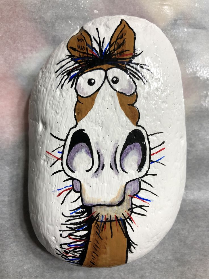 a painted rock with a horse's face on it