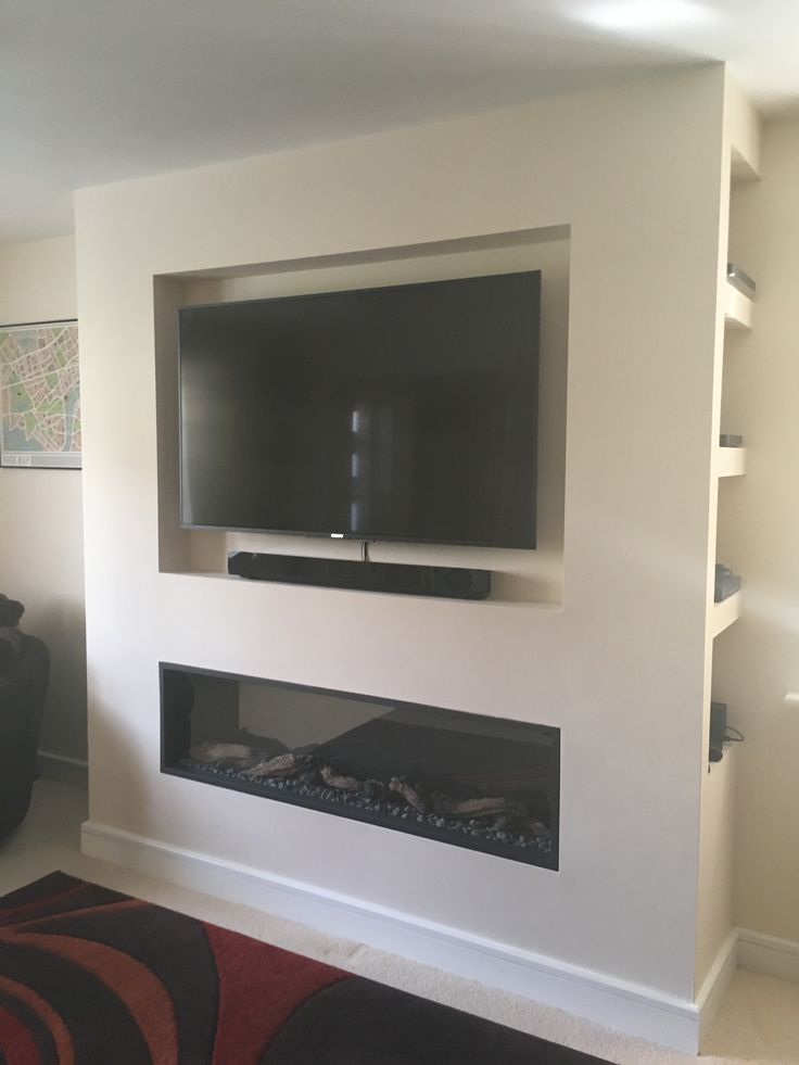 a flat screen tv mounted on the wall above a fireplace