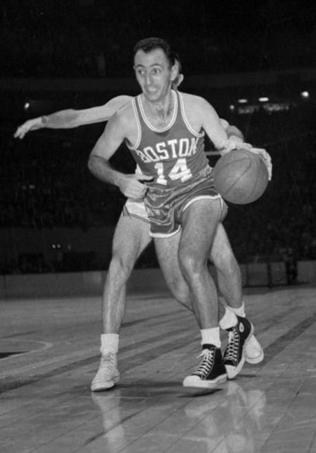 an old photo of a man holding a basketball