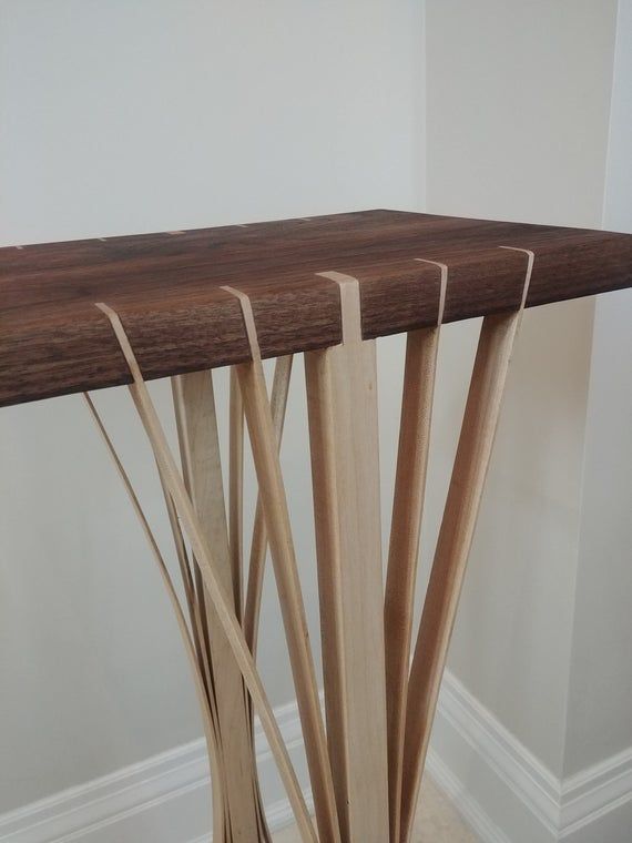 a wooden table that has some sticks sticking out of it's sides on the floor