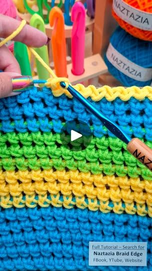 someone is crocheting the edges of a multicolored blanket with scissors and yarn