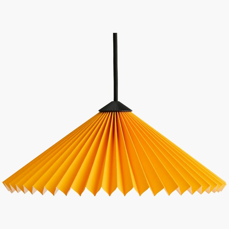 a yellow paper lamp hanging from a black metal hook on a white background with the light turned off