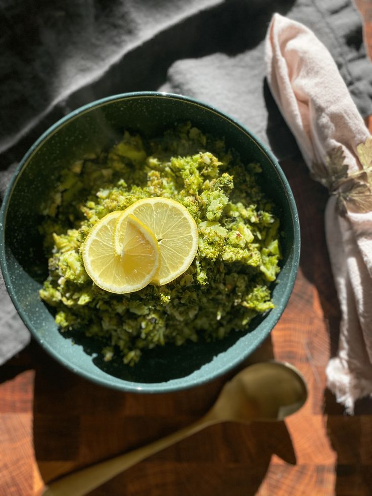 a bowl filled with broccoli and lemon slices