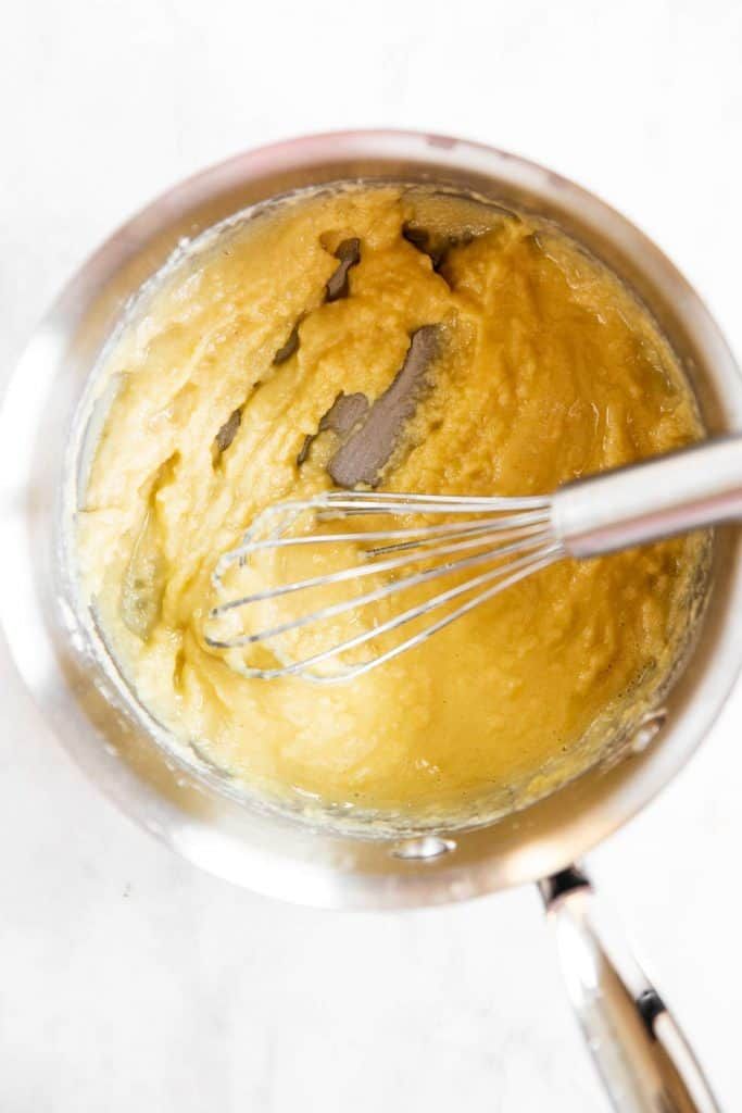 a mixing bowl filled with batter and whisk on top of a white counter