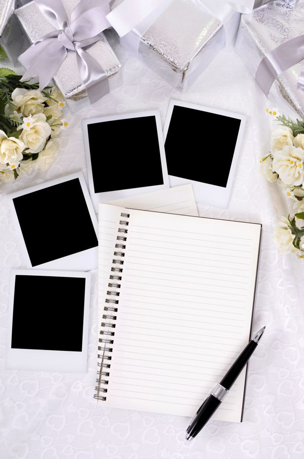 four blank photos are placed on top of an open notebook with flowers in the background