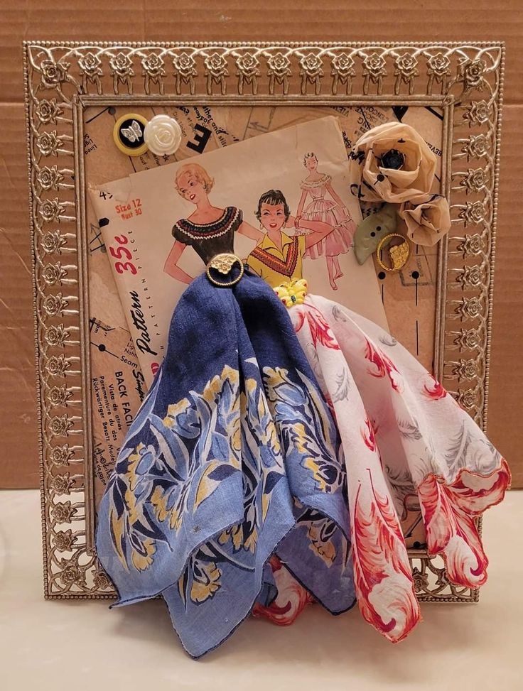 three scarves are sitting in front of a picture frame with an image on it