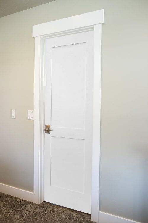 an empty room with a white door and carpet