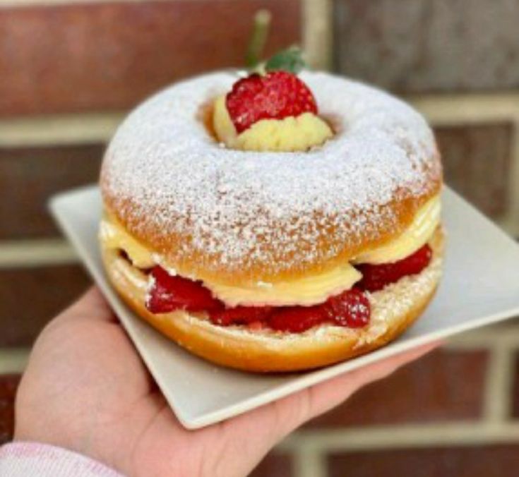 a strawberry filled donut with powdered sugar on top