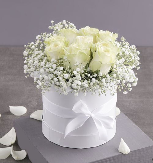 white roses and baby's breath in a box