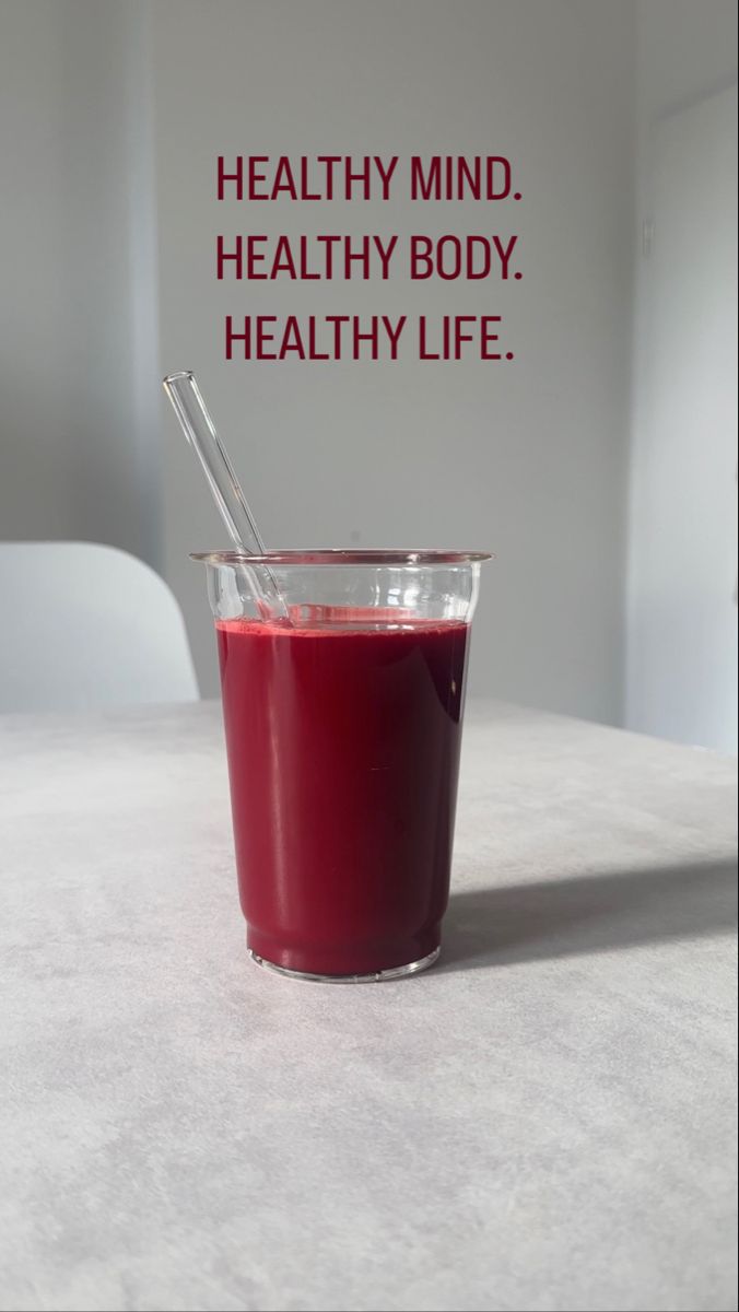 a smoothie with a straw in it sitting on a table next to a sign that says healthy mind, healthy body, healthy life