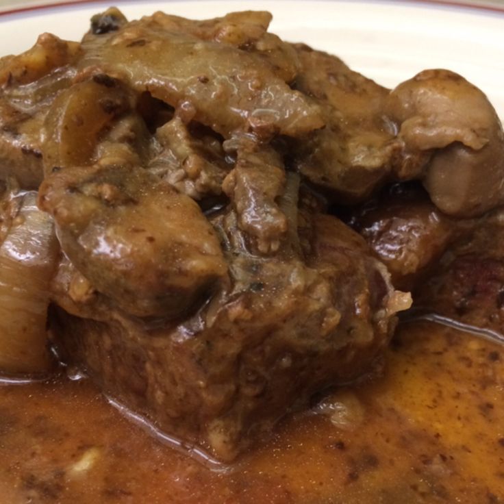 a white plate topped with meat covered in gravy