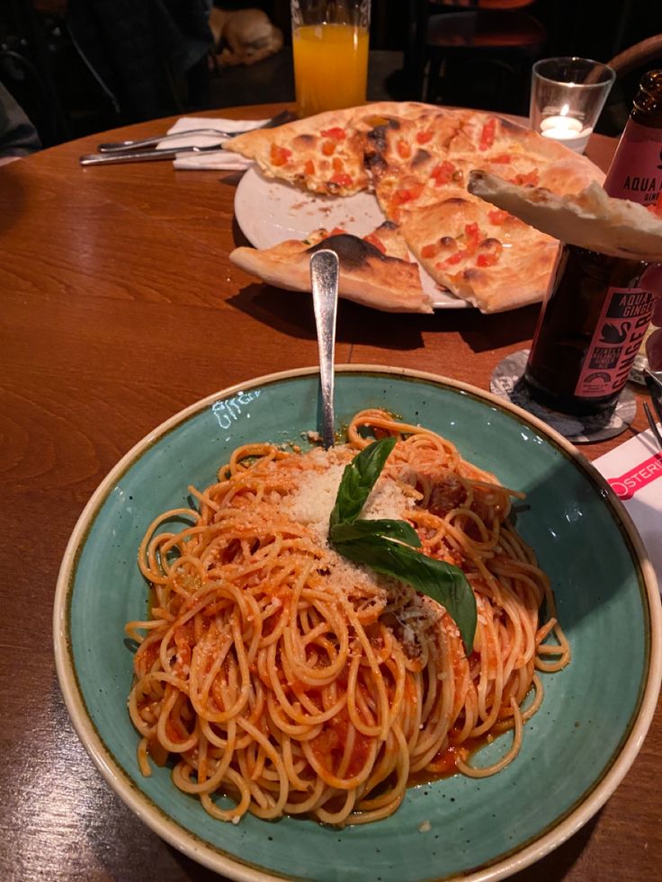 a plate of spaghetti and pizza on a table