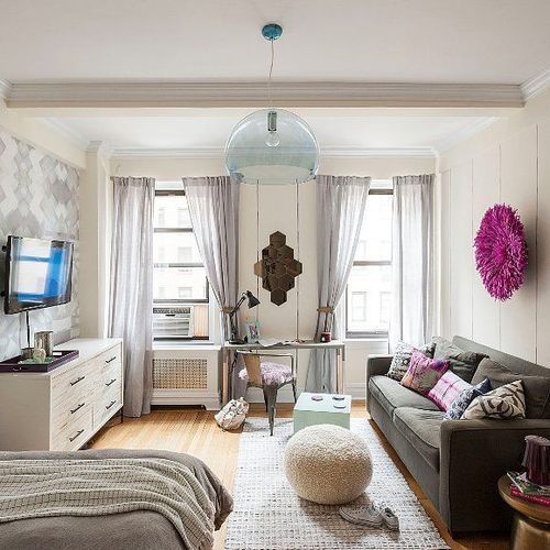 a living room filled with furniture and a flat screen tv on top of a wooden floor