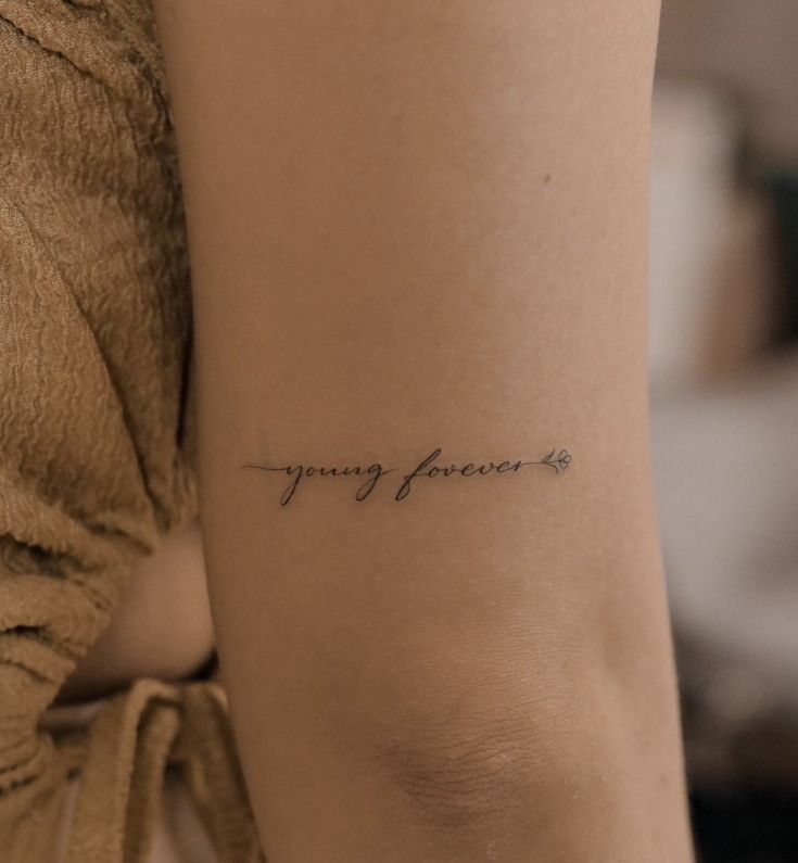 a woman's arm with a tattoo that says happy forever on the left side