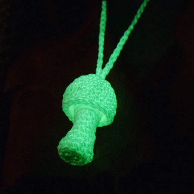 a green glow in the dark necklace with an elephant head on it's back