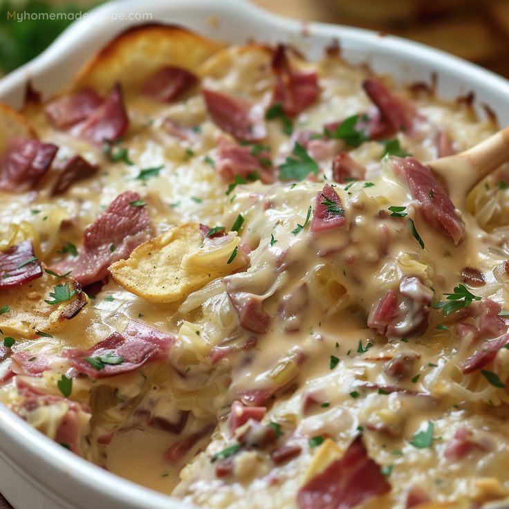 a casserole dish with ham, potatoes and gravy in a white bowl