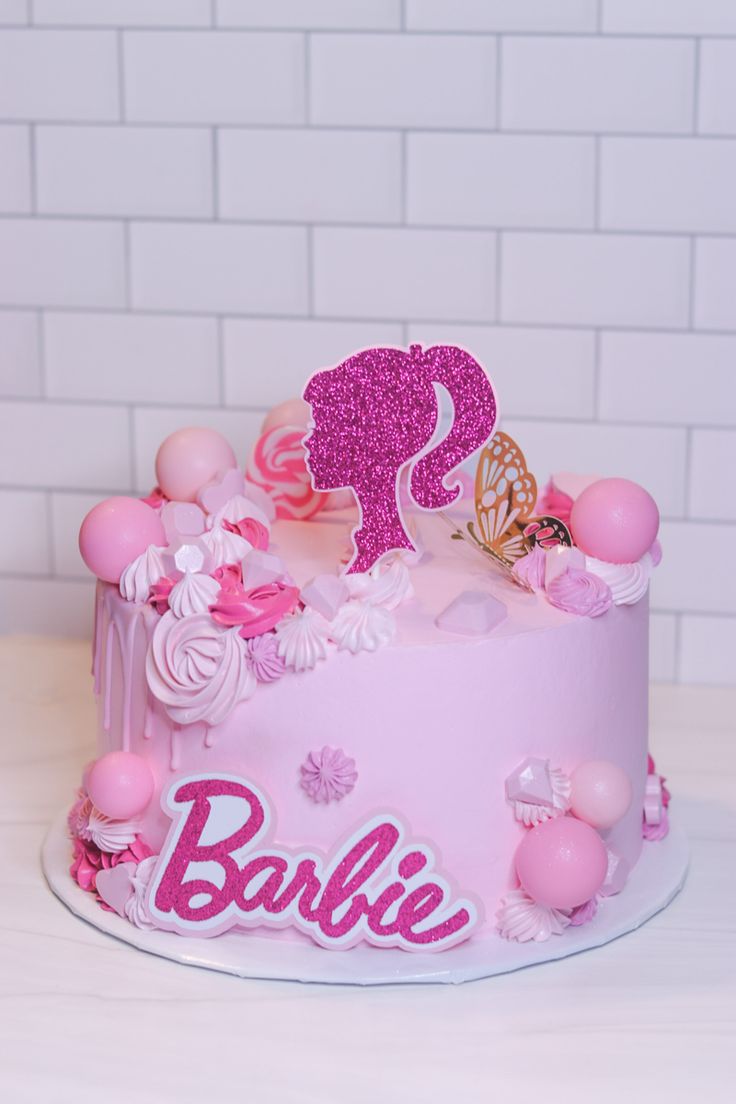 a pink cake with an elephant and name on it